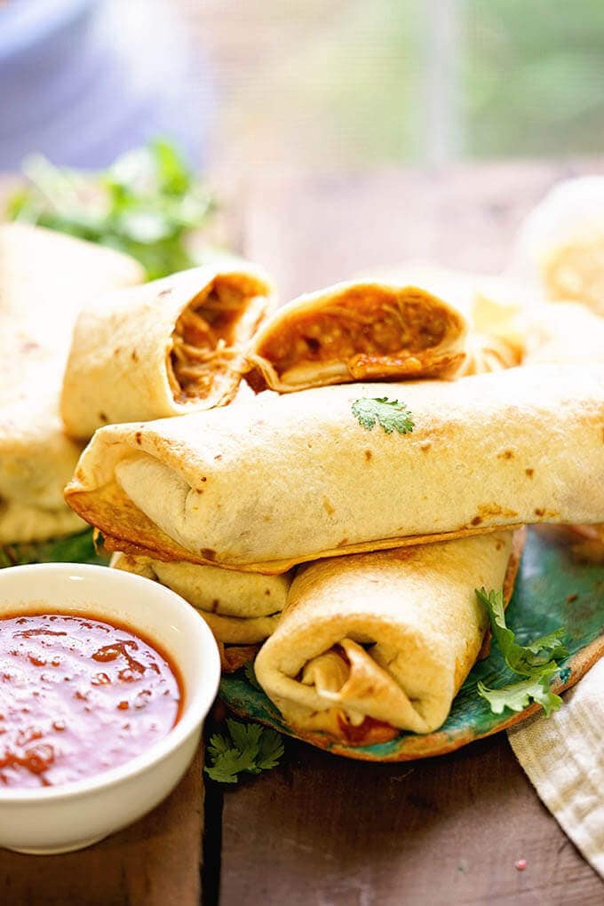 A platter of chicken chimichangas served with salsa.