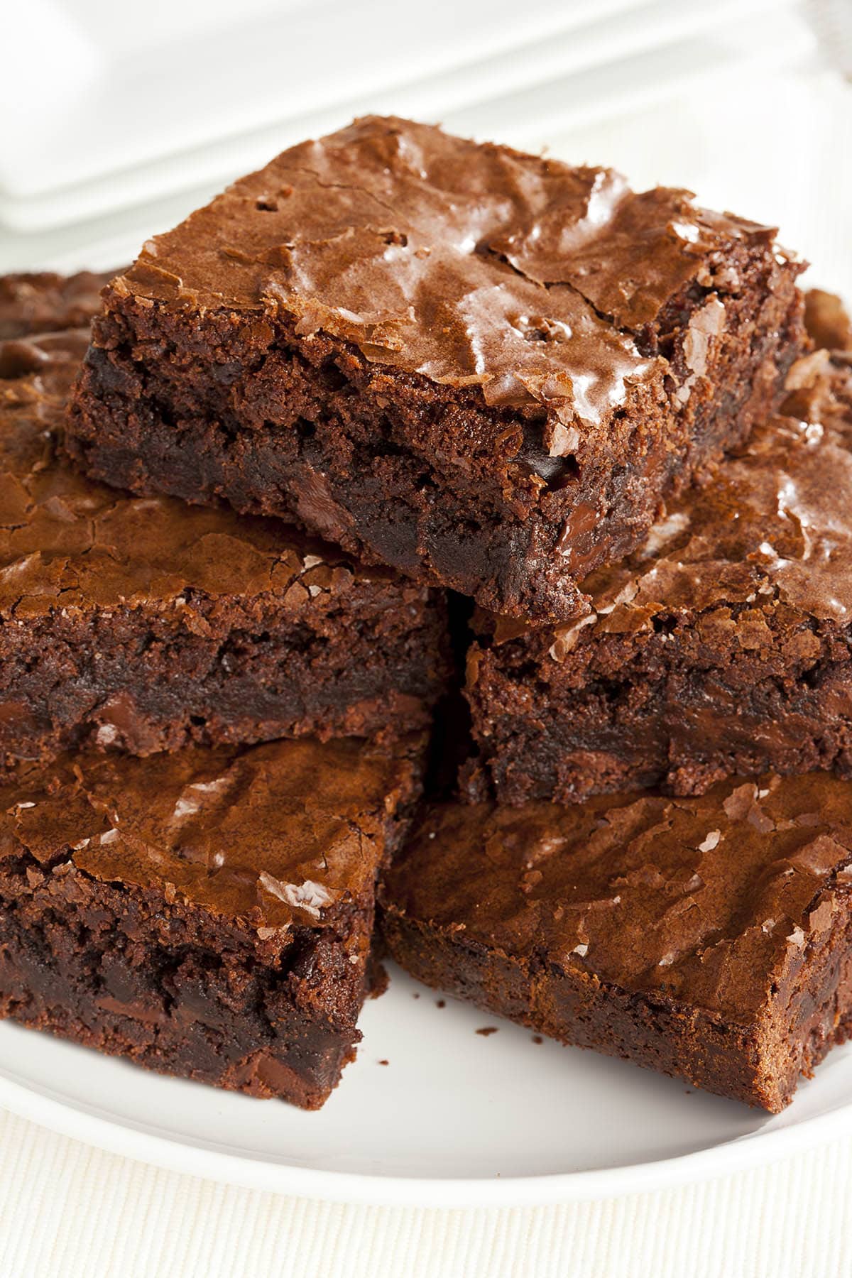 Brownies stacked on a white plate.
