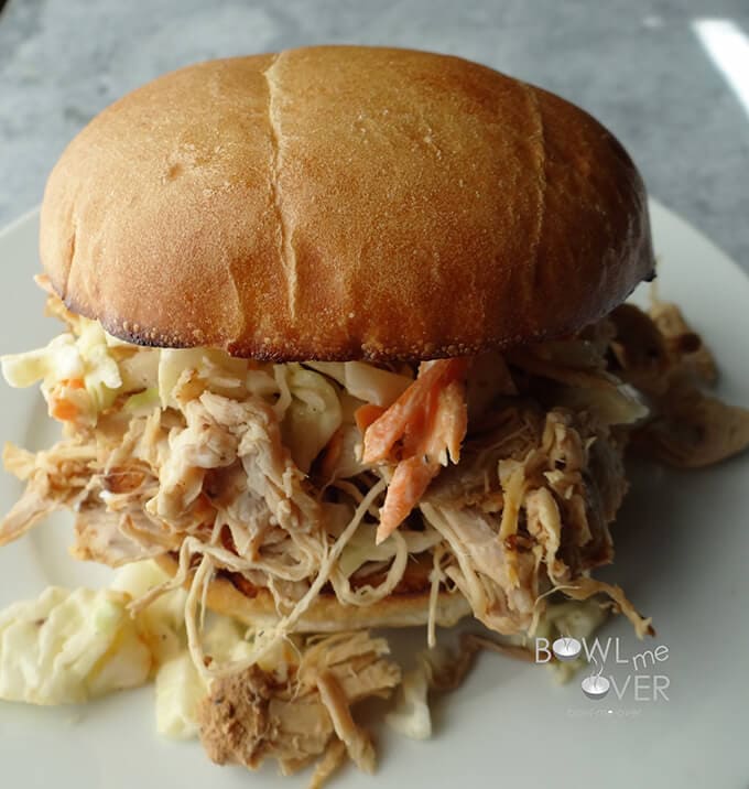 Kauai Pulled Pork sandwich on plate with logo print overlay.