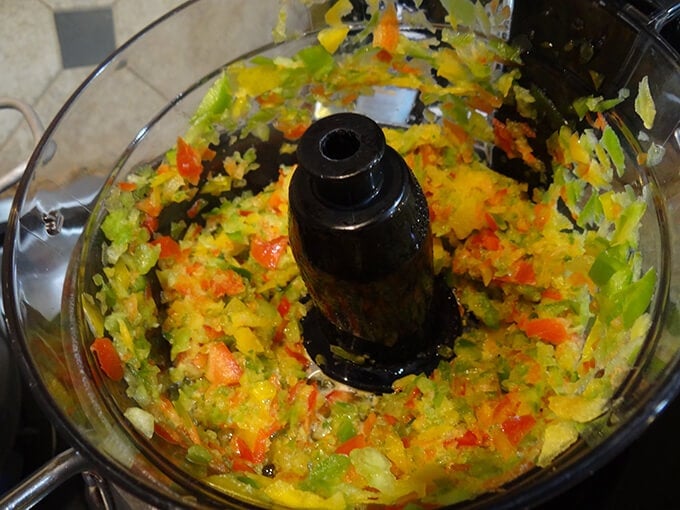 Green, yellow, red and jalapeños peppers chopped in a food processor.