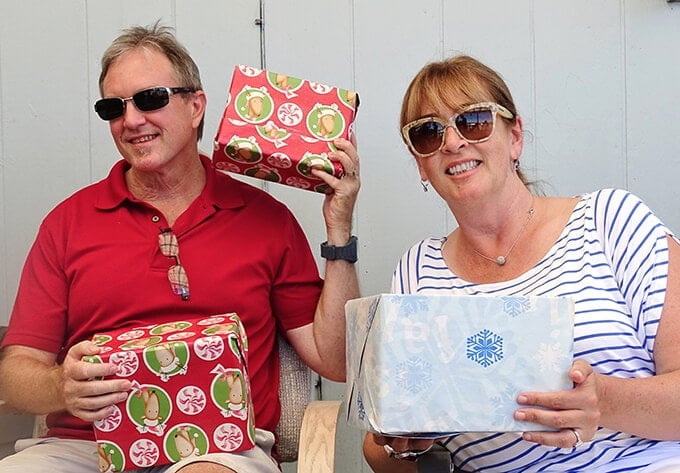 Dan and Deb holding wrapped Christmas presents.