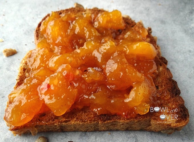 A slice of toasted bread spread with homemade mango jam.