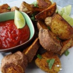 Crispy sweet potato wedges on platter with ketchup.