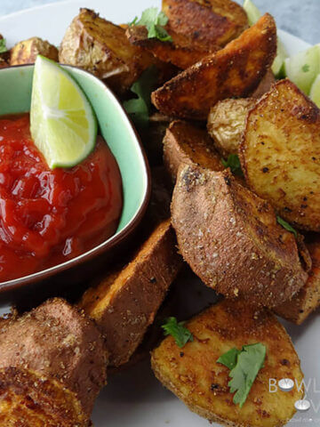 Crispy sweet potato wedges on platter with ketchup.