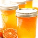 Jars of Mandarin Orange Jelly with fresh mandarins.