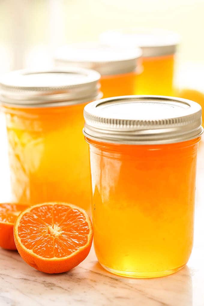 Jars of Mandarin Orange Jelly with fresh mandarins.