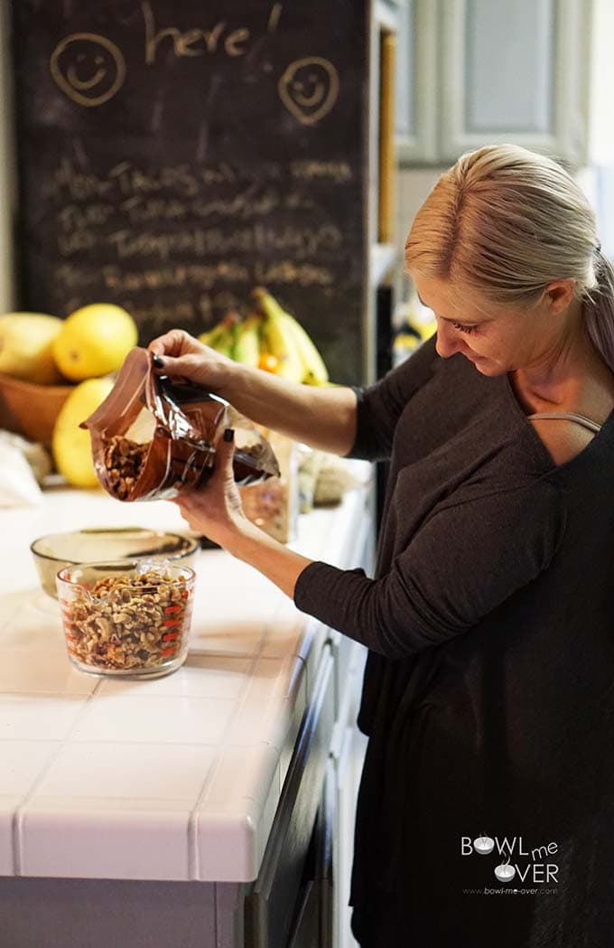 Woman measuring nuts into measuring cup. 