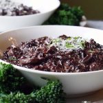 White Bowls filled with risotto made with black forbidden rice.