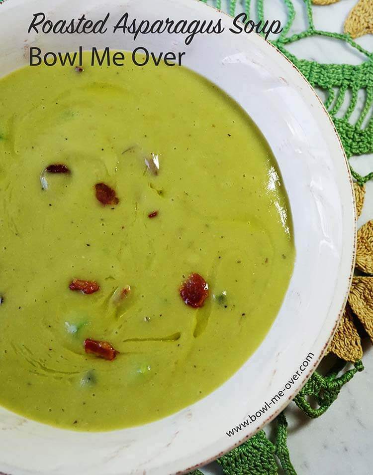A bowl full of bright green asparagus soup! The soup is topped with crunchy bacon bits