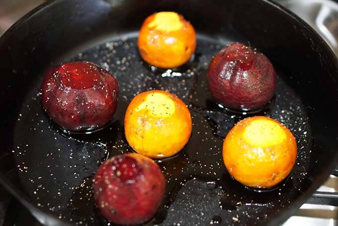 Beets being roasted in cast iron skillet.
