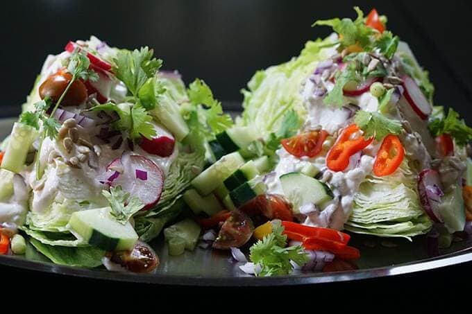 Two slices of wedge salad on silver platter.
