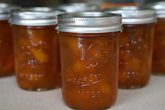 Canning jars filled with Spiced Apricot Jam.