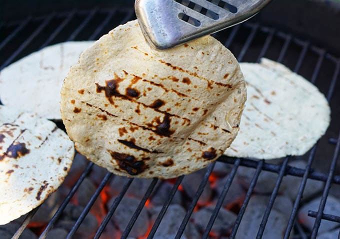 Corn tortillas cooking on the grill.