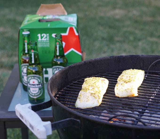 Fish fillets cooking on a charcoal grill.