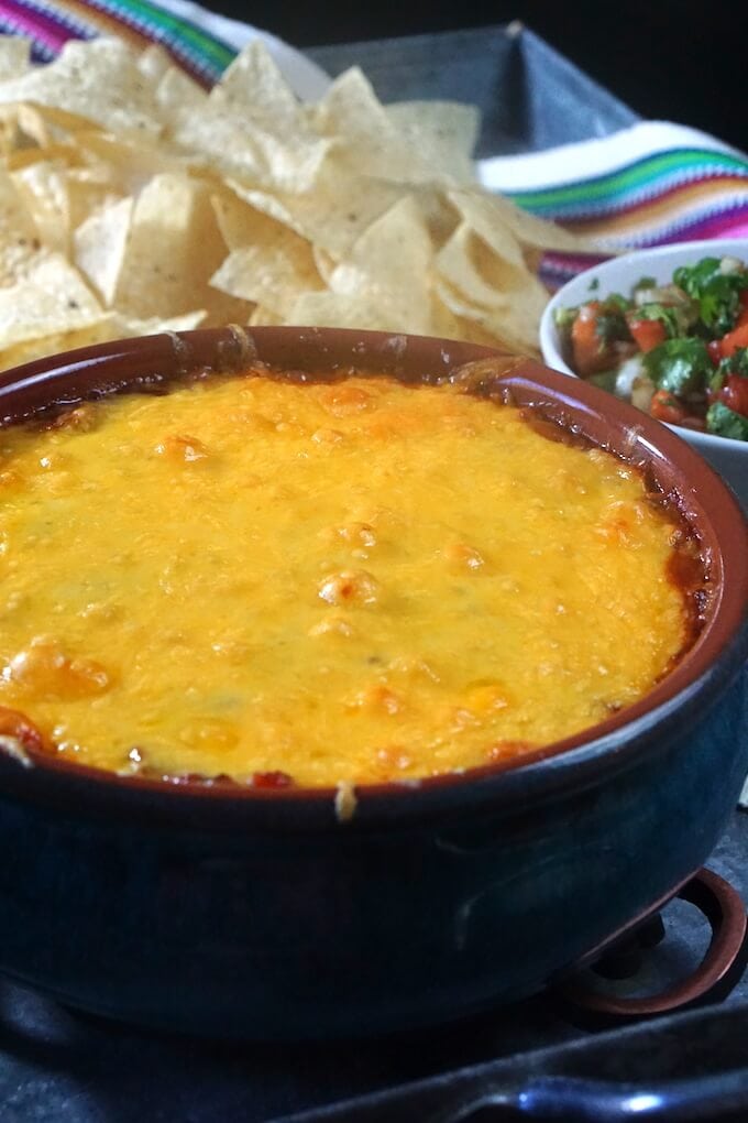 A Blue Ceramic Dish Filled With A Cheesy Hot And Bubbly Refried Bean