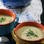 2 bowls of Cream of Zucchini Soup on topped with fresh cracked black pepper and shredded basil.