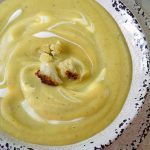 A white bowl filled with creamy cauliflower soup.