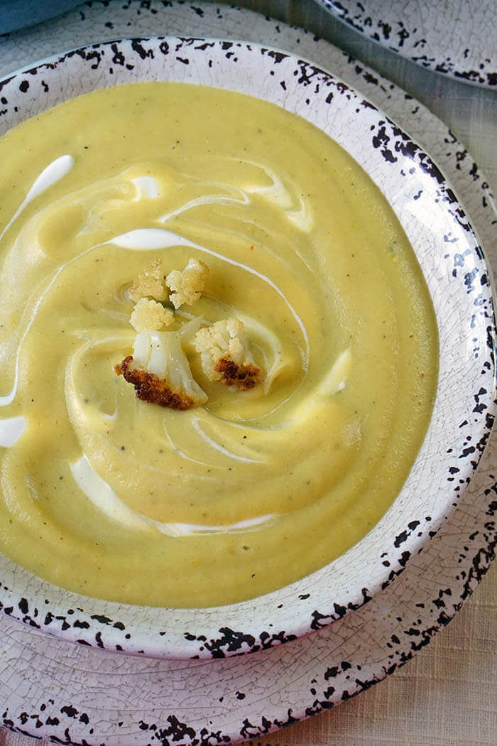 A white bowl filled with creamy cauliflower soup.