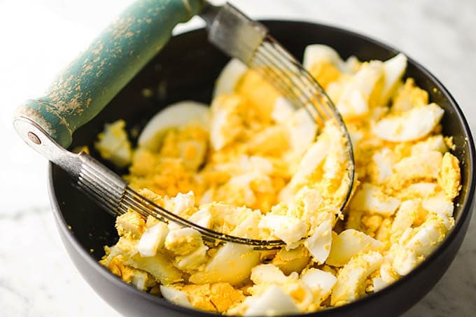 Chopped boiled eggs in a black bowl.