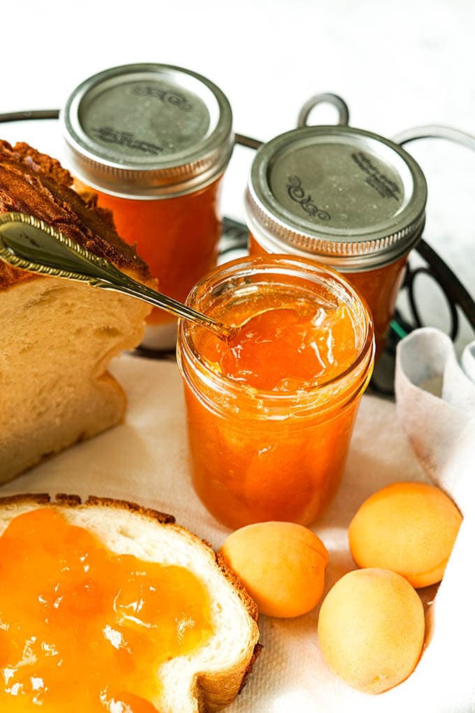 Apricot Jam on bread with jars of jam