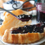 Low sugar blueberry jam spread on croissant.