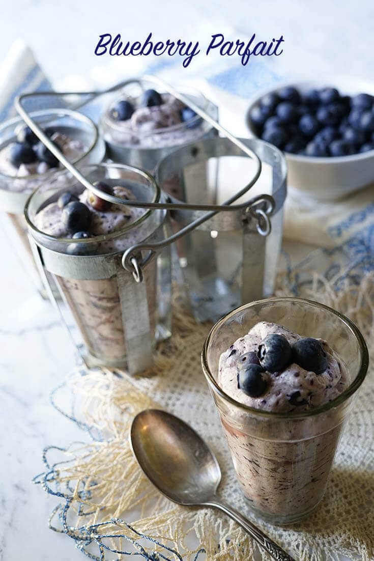 Pretty blueberry parfaits in serving glasses with fresh blueberries. 