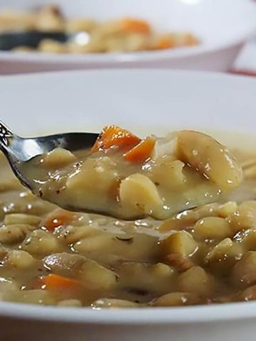 Bean with Bacon Soup recipe with spoon filled with soup.