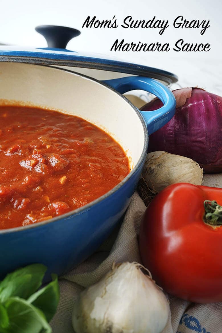 Marinara Recipe in a blue sauce pan surrounded by fresh tomatoes, garlic and onions and basil. With print overlay.