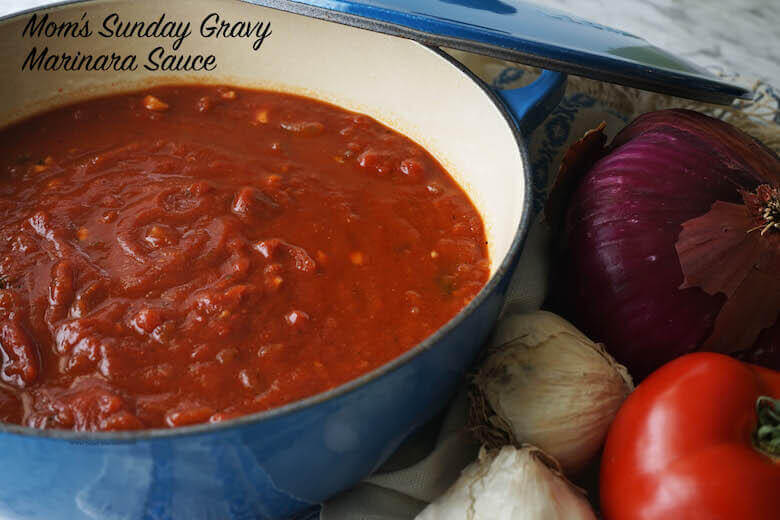 This is a recipe for Marinara Sauce or red sauce in a blue pot surrounded by fresh vegetables.