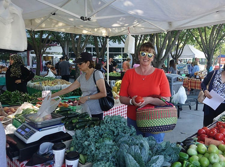 Woman at farmers market with basket. 