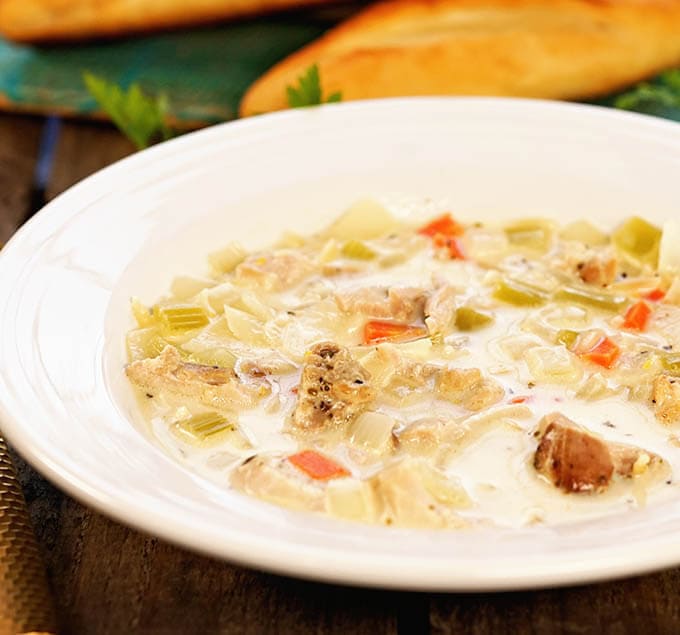 A white bowl filled with Lemon Chicken Orzo Soup Recipe.