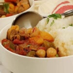 Moroccan chicken stew in bowl with spoon.