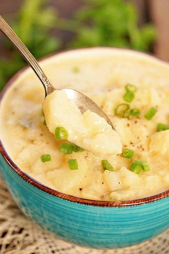 Easy Creamy Potato Soup in blue bowl with spoon.