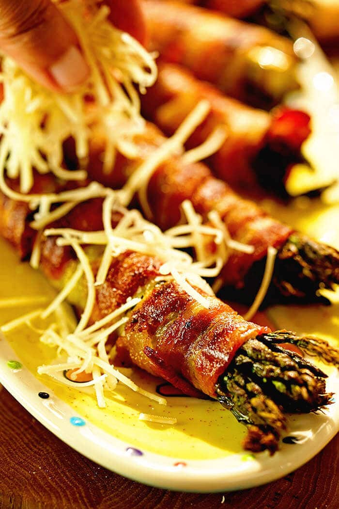  Un plateau d'asperges enveloppées de bacon saupoudrées de parmesan.