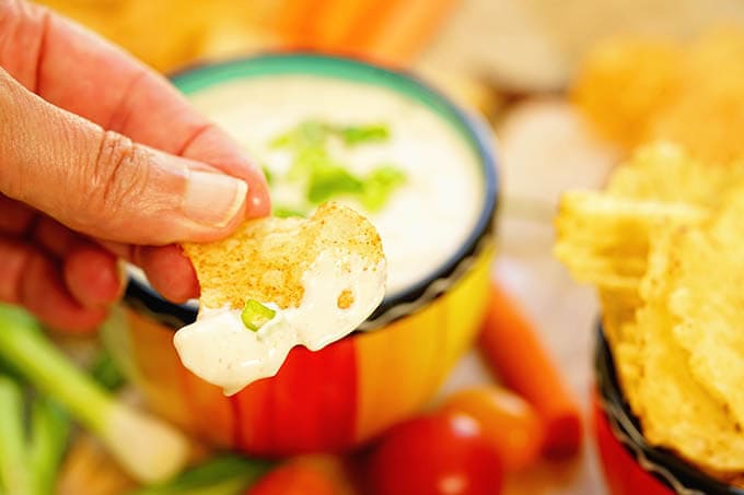 Potato chip dunked into dip.