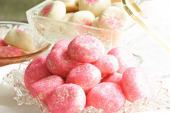 Pink cookies on glass platter.