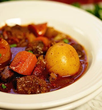 Stew in white bowl. The stew is full of tender lamb morsels and big chunky vegetables.