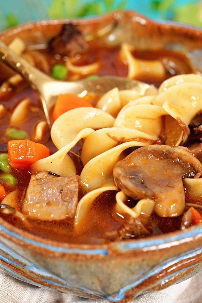 Beef Noodle Soup Recipe with roast beef, noodles, carrots, mushrooms and peas.
