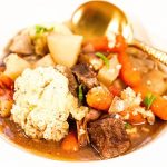 Easy Crockpot Beef Stew in a white bowl with spoon.