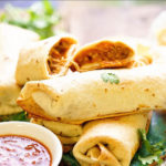 Chicken Chimichangas on a platter served with red salsa.