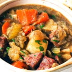 Corned Beef and Cabbage soup in a tan bowl with crackers