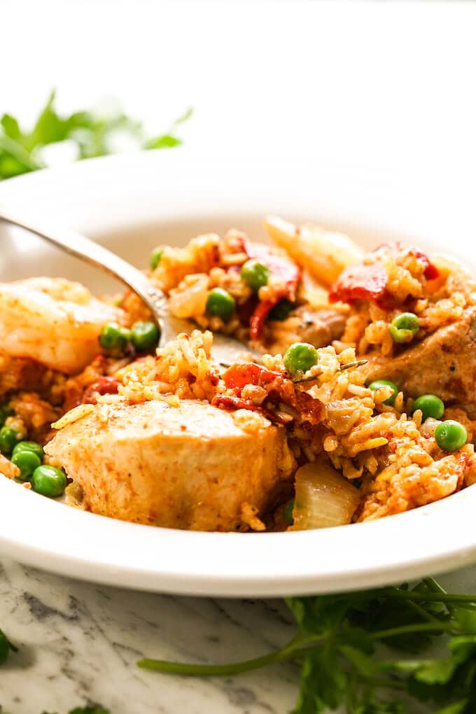 Paella in a white bowl with fork.