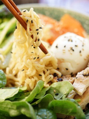 Ramen Noodle Recipe in bowl served with chopsticks, topped with a soft boiled egg.