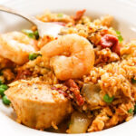 Seafood and chicken Paella in bowl with fork.