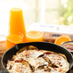 Easy Huevos Rancheros Recipe in cast iron skillet with orange juice.