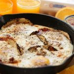 Easy Huevos Rancheros Recipe served with orange juice and a bowl of salsa.