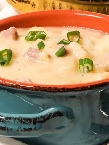 Potato and Ham Soup in blue bowl topped with chives.