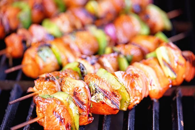 Chicken skewers on bbq'ing on a gas grill.