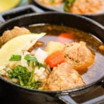Mexican Meatball Soup in cast iron bowls topped with lime