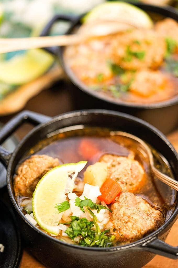 Mexican Meatball soup in black bowl with spoon